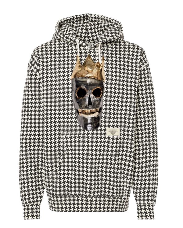 A limited edition houndstooth hoodie featuring the King is Black design. The central artwork depicts a crown black skull with interactive details prominently displayed on the chest.